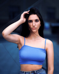 Young woman in blue crop top looking at the camera