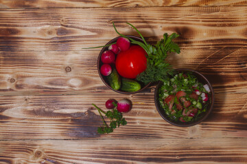 Rustic vegetable salad of fresh vegetables on a brown wooden background