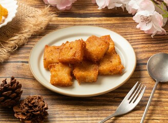 stirred fried turnip cake in dish side view on wooden table taiwan style food