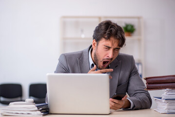 Young male employee in oversleeping concept