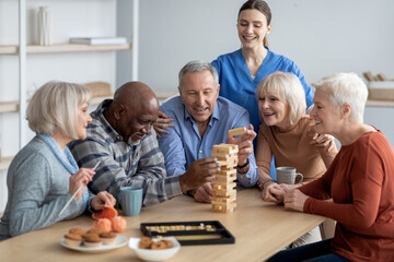 Happy multiracial group of pensioners playing table games