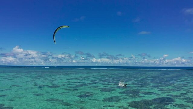 Caribbean beach background. Sunny tropical beach. Aerial view young man kite surfing in tropical blue ocean