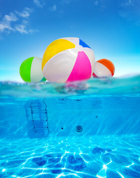 Inflatable balls float in water, split underwater pool image