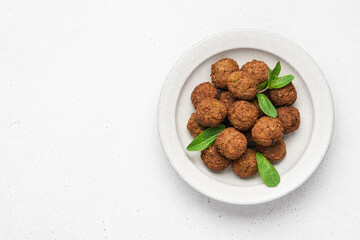 Chickpea falafel balls decorated with mint leaves in bowl on white background. Healthy vegan food concept