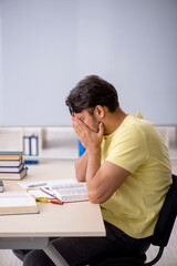 Young male student preparing for exams in the classroom