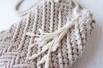 Handmade macrame bag. ECO friendly natural macrame cotton cross-body bag. Hobby knitting handmade macrame. Modern summer concept. Close up.