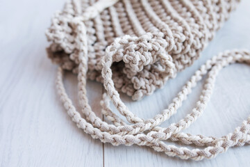 Handmade macrame bag. ECO friendly natural macrame cotton cross-body bag. Hobby knitting handmade macrame. Modern summer concept. Close up.