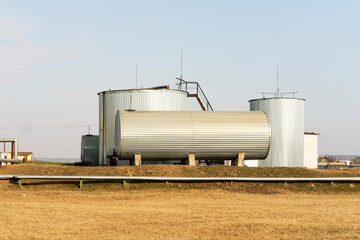 Obraz premium View of industrial tanks for storage of liquid production materials. Alcohol or chemistry.