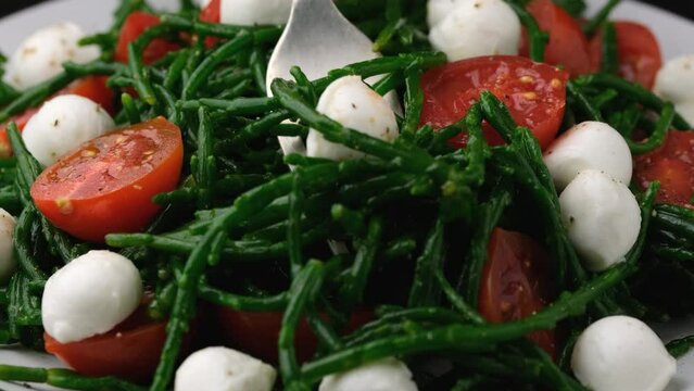 Eating Samphire salad with cherry tomatoes and mozzarella. Healthy food