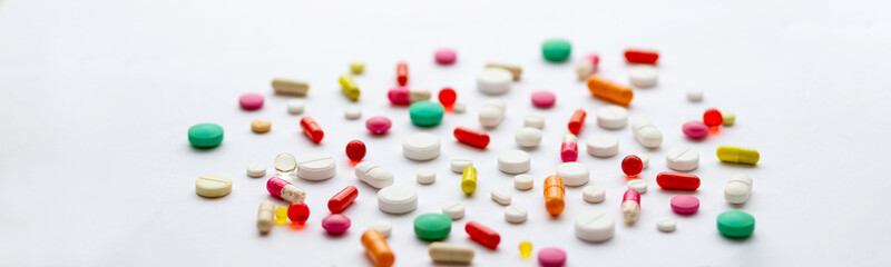 Creative layout of colorful pills and capsules on green background. Minimal medical concept. Pharmaceutical, Covid-19. Flat lay.Medication and prescription pills . Virus epidemic.