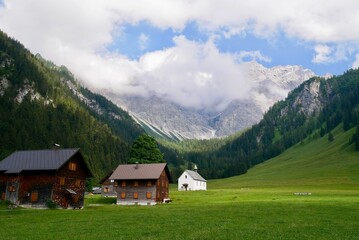 Fototapeta na wymiar Traditional mountain huts and chapel Sankt Rochus in Nenzinger Himmel. Vorarlberg, Austria.