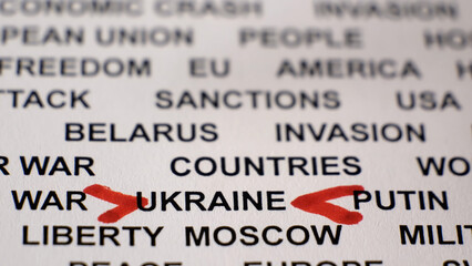 Closeup shot of UKRAINE written on white paper with red arrows. Sanctions. Crisis. Military activities. Russian invasion of Ukraine concept. 