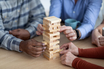 Cropped of multiracial elderly people playing jenga at home