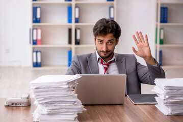 Young male employee unhappy with excessive work in the office