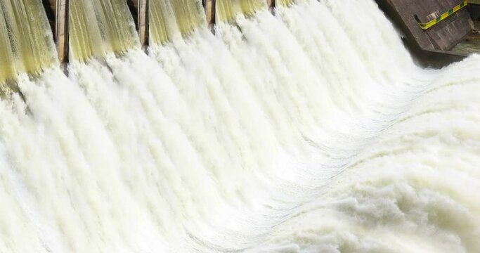Hydroelectric power plant, river dam with flowing water at hydroelectric power station, force of water, renewable energy, slow motion