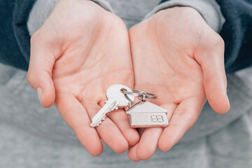 hands with keychain and house keys