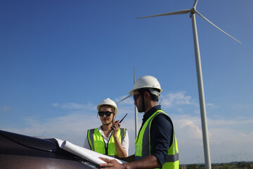  Two engineer colleage read drawing working on front vehicle, Wind turbine green energy