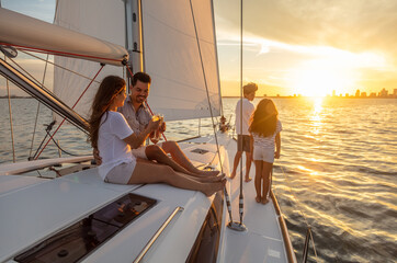 Hispanic family relaxing on luxury yacht at sunset - obrazy, fototapety, plakaty