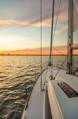 Obraz na płótnie Canvas Sailing on luxury yacht towards cityscape at sunset