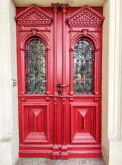reich verzierte rot bemalte Haustür an einem Bürgerhaus