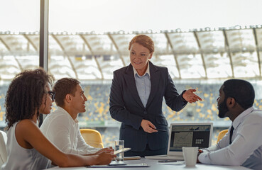 Multiracial coworkers group working together at office of stadium