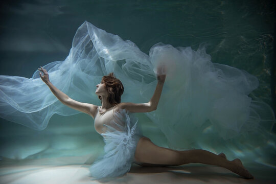 Dancing woman underwater in the pool in a tutu, she looks like a Mermaid. Surreal photography.