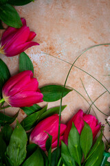 Row of red tulips on wooden background with space for message. Mother's Day background. Top view