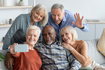 Five cheerful elderly friends taking selfie on mobile phone