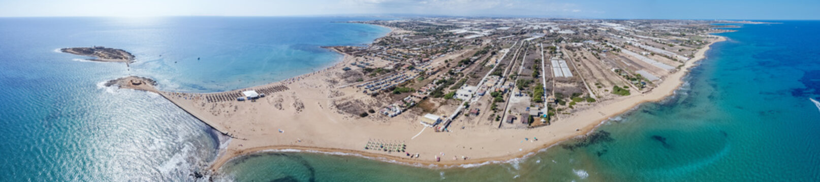 Aerial drone view of island and beach of Isola delle Correnti. Lighthouse surrounded by clear turquoise sea water in Portopalo di capo Passero, Sicily