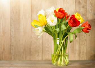vase with tulips on wooden background