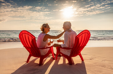 Senior Caucasian couple on sandy beach at sunset
