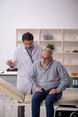 Old man in wheelchair visiting young male doctor