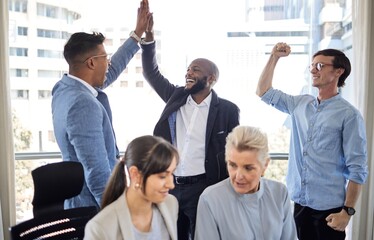 We earned this exceptional achievement. Shot of a group of businesspeople cheering in an office.