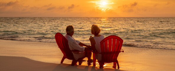 Panoramic retired couple enjoying sunset on tropical island