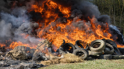 Burning landscape. Vehicle tires and haystacks on fire, black smoke invading the...