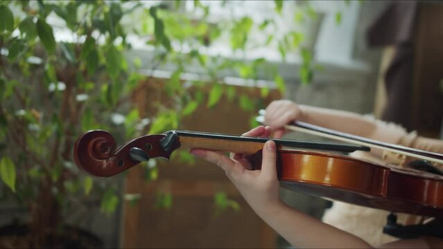 The girl can not play the violin. She winces and gets upset