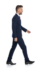 businessman wearing a navy suit and walking on his wa