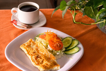 Omelette con taza de café y ensalada 