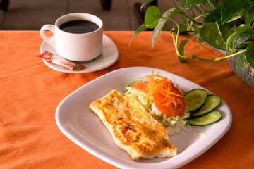 Omelette con taza de café y ensalada 