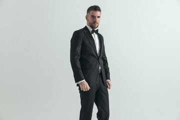 businessman wearing a nice tuxedo and posing with style