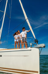 Smiling Latin American family standing on private yacht