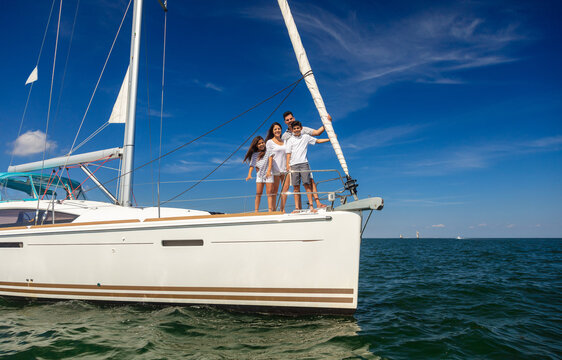 Latino Family Enjoying Sailing Vacation On Private Yacht