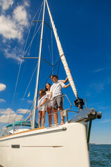 Latin American family standing on bow of yacht