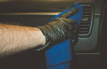 Car detailing services, car wash and cleaning concept. Male worker cleaning car steering wheel with...
