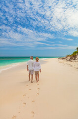 Mature couple walking on beach leaving footprints Bahamas