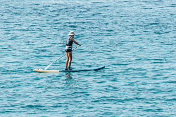 Boy Paddling On SUP or Stand Up Paddle Board In The Ocean Sea