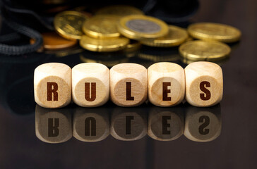 On a black surface are coins and cubes with the inscription - RULES
