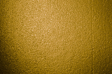 Textured background. Styrofoam in yellow light. Polystyrene foam close-up. Lots of small and large bubbles. New Year color backdrop. Wallpaper with copy space. Building material. Macro. Rough surface