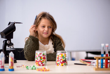Young little girl chemist in drugs synthesis concept