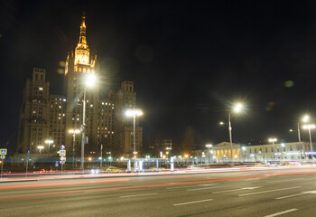Fototapeta na wymiar Moscow, Russia, Mar 3, 2022: Night view of Kudrinskaya square. Old soviet skyscraper. Traffic, Car traces.